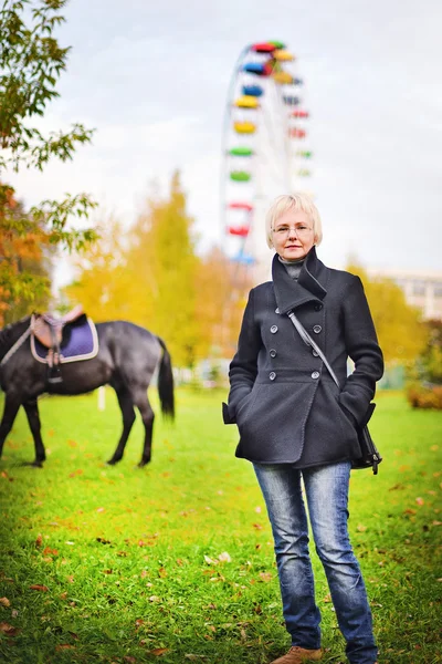 Mujer de mediana edad en el parque de otoño —  Fotos de Stock