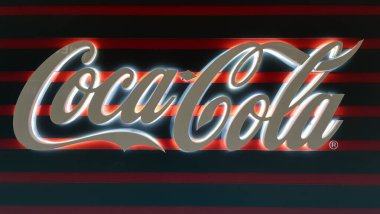 Karanlıkta parlayan beyaz bir Coca-Cola işareti. Coca Cola işareti. Alkolsüz karbonatlı içecek. Ukrayna, Kiev - 05 Ocak 2021