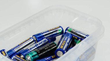 Özel atık kutularında geri dönüşüm için toplanan kullanılmış AA alkalin ve lityum iyonlu pillerle dolu plastik kutuları temizleyin. Geri dönüşüm ve ekoloji sorunları. Ukrayna, Kiev - 7 Ocak 2021