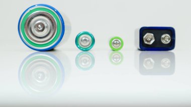 Pil tipi D veya C, PP3, AA, beyaz arka planda yansıması olan AAA. Metal alkalin bataryaların fotokopi alanı görüntüsü. Zorunlu işlem