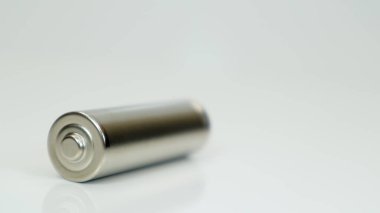 AA alkali şarj edilebilir batarya beyaz parlak arka planda ve yansımalı. Boş bir bataryayı kopyalama alanı ile kapat.