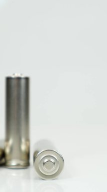 AA alkali şarj edilebilir piller beyaz parlak arka planda ve yansımalı. İki boş bataryayı fotokopi alanıyla kapat. Dikey fotoğrafçılık