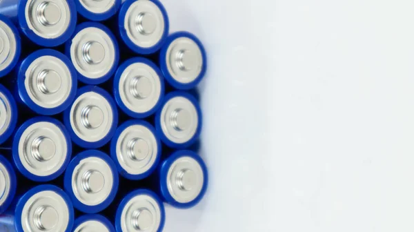 Lots of AA and AAA alkaline batteries on a white background. Ecological recycling concept. The terminals of the disposable batteries are close together and form a beautiful backdrop. Energy source