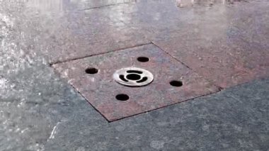 Meydanda bir yaya çeşmesi deresi, yakın plan. Şehir merkezinde yere gömülü bir gayzer başlığından sokaktaki bir çeşmeden su fışkırıyor.