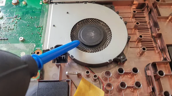 Laptop soğutucusuna yakın çekim. Laptop soğutma sisteminin bakımı ve önlenmesi. Elektronik cihaz onarım konsepti. Bilgisayar vantilatöründe toz ve pislik var. Bilgisayarın sökülmesi