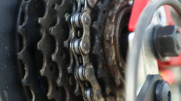 Nahaufnahme eines hinteren Gangschaltzahnrads am Hinterrad eines modernen Mountainbikes mit Kette. Fahrradreparatur. — Stockfoto
