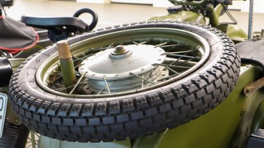 Efsanevi Alman BMW 'sinin bir kopyası olan kamuflaj sepetli eski bir Sovyet askeri motosikleti K-750. Bebek arabasının üstünde yedek bir tekerlek var. Yakın plan.