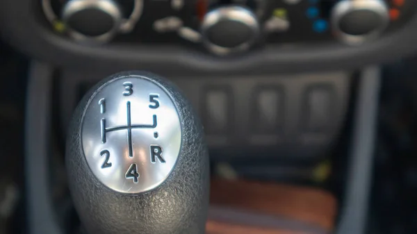 Knob for selecting the gear of a manual gearbox. Manual transmission knob in the car. Close-up of the gear shift lever. Vehicle interior. Detail of the car