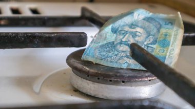 Gazlı su ısıtıcısında ateş olmayan Ukrayna Hryvnia 'sı. Paralı gaz ocağı. Şiddet için artan tarifenin kavramsal görüntüsü. Doğalgaz tasarrufu kavramı, yüksek benzin fiyatları