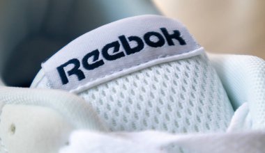 Reebok ayakkabılarını imzala. Dünyanın en büyük spor giyim ve ayakkabı şirketlerinden biri. Reebok logolu yeni beyaz ayakkabılar. Spor ve sıradan ayakkabı kavramı. Ukrayna, Kiev - 18 Haziran 2021
