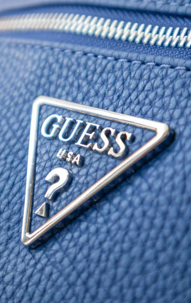 ブルーレザーショルダーバッグによるGuess 三角形の金属のロゴを閉じる ウクライナ キエフ 2021年6月17日 — ストック写真