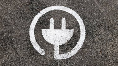 Halka açık bir otoparkta arabalar için elektrikli şarj sembolü..