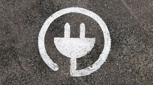 Halka açık bir otoparkta arabalar için elektrikli şarj sembolü..