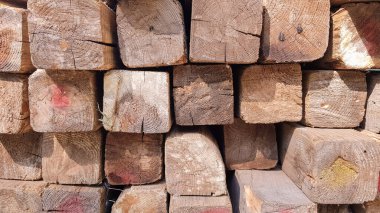 Yığınla kereste. Katlanmış odun. Kapalı ahşap tahtalar. Tahtanın yüzeyi. Depoda üst üste yığılmış kalaslar.