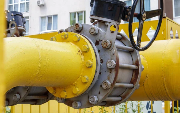 Yellow gas pipe with a tap. Oil pipeline fittings in the oil and gas industry. Oil and gas processing plant with pipeline fittings. Industrial safety valve