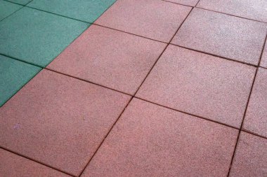Oyun parkları için yapay lastik kaplama. Sentetik malzeme. Yağmurlu havalarda açık hava çocuk parkının renkli arka planı. Etkin yaşam tarzı, egzersiz konsepti