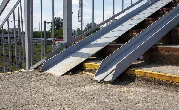 The staircase of the pedestrian crossing with traces of destruction. Two wheelchair rails. Metal railings for bicycles, wheelchairs and strollers with children. Special equipment on the stairs