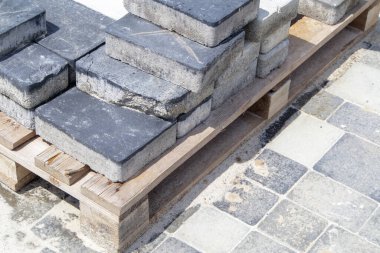 Beton ya da asfalt döşeme levhaları ya da zemin ya da palete istiflenmiş kaldırım taşları. Arka bahçedeki beton kaldırımlar ya da kaldırımlar. Bahçede kumlu bir temelde bahçe tuğlası yolu var.