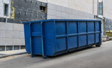 İnşaat alanındaki açık hava çöpleri için metal dayanıklı mavi endüstriyel çöp kutusu. Ev ya da endüstriyel atıklar için büyük bir çöp kutusu. Bir çöp yığını.