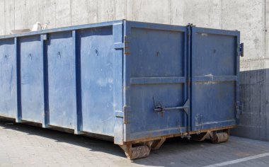 İnşaat alanındaki açık hava çöpleri için metal dayanıklı mavi endüstriyel çöp kutusu. Ev ya da endüstriyel atıklar için büyük bir çöp kutusu. Bir çöp yığını.