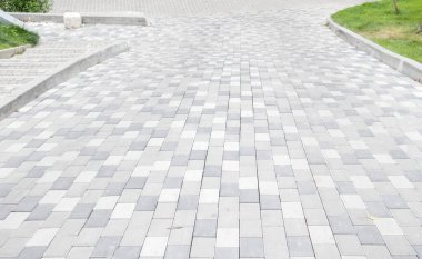 Gri asfalt levhalarla kaplı uzun bir iniş. Rampa beton kiremitlerle döşenmiş. Tekerlekli sandalye ve bisiklet ulaşımı kavramı