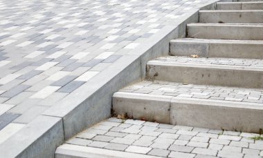 Kaldırım levhaları ve kaldırımlar. Gri kaldırım levhalarından yapılmış gri basamaklar birbirine eşit, tutarlı ve sıkıca dizilir. Asfalt basamaklar gri arkaplan