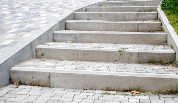 Kaldırım levhaları ve kaldırımlar. Gri kaldırım levhalarından yapılmış gri basamaklar birbirine eşit, tutarlı ve sıkıca dizilir. Asfalt basamaklar gri arkaplan
