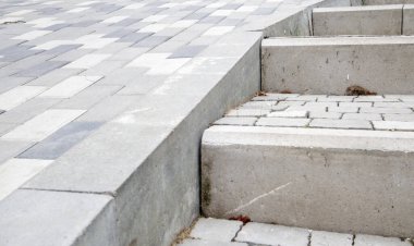 Kaldırım levhaları ve kaldırımlar. Gri kaldırım levhalarından yapılmış gri basamaklar birbirine eşit, tutarlı ve sıkıca dizilir. Asfalt basamaklar gri arkaplan