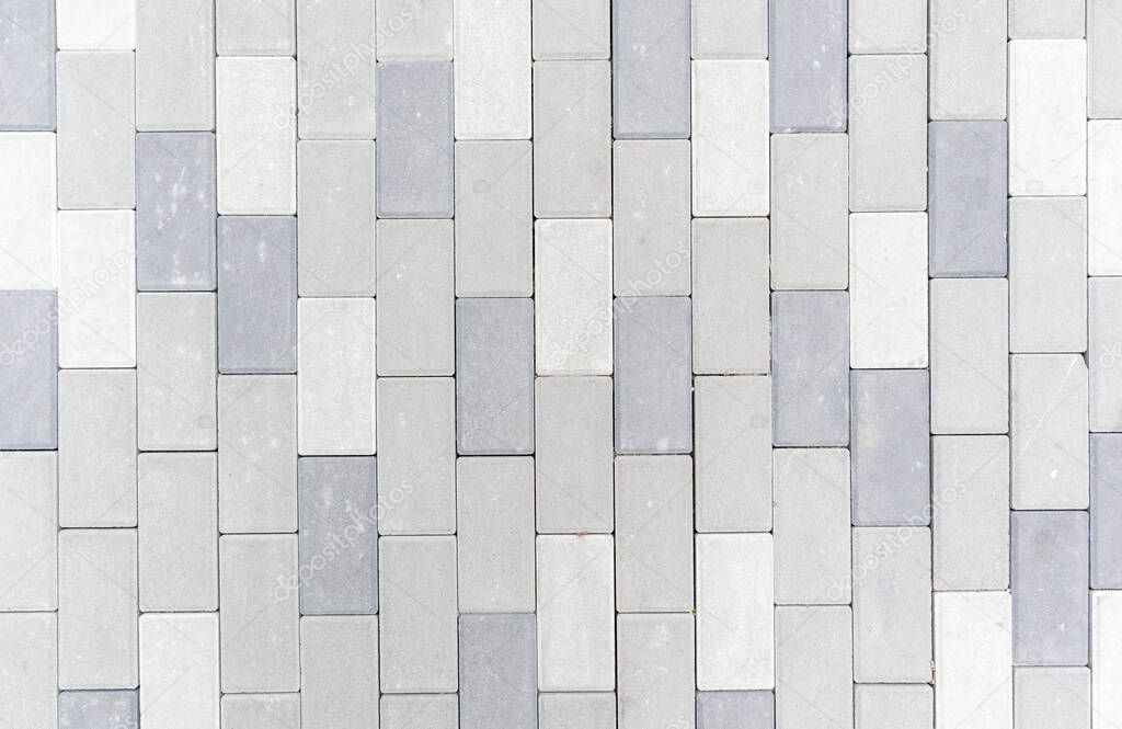 Concrete or paved newly laid gray paving slabs or stones for floors or walkways. Concrete paving slabs in the backyard or road paving. Garden brick path in the courtyard on a sandy foundation