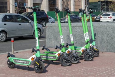 Şehirde elektrikli scooterlar kiraya verilebilir. Elektrikli scooter kiralama popüler bir ulaşım aracıdır. Her yaşa uygun ve rahattırlar. Ukrayna, Kiev - 13 Eylül 2021