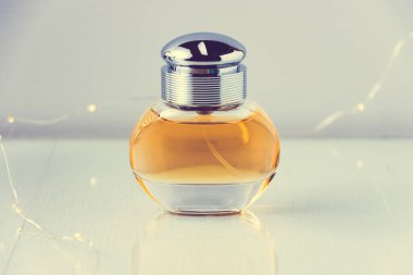 Parfüm şişesinin stüdyo fotoğrafı arka planda küçük ışık telleriyle.