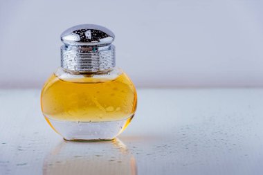 Arka planda su damlaları olan parfüm şişesinin stüdyo fotoğrafı.