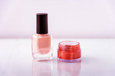 Beyaz arkaplanda pembe oje ve kırmızı pigment resmi 