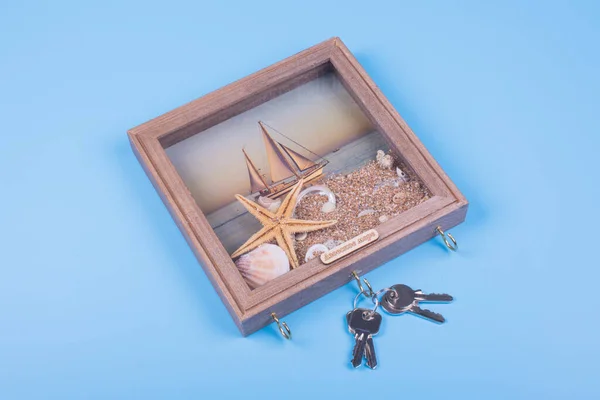 souvenir picture with hooks on which to hang the keys from the house, top view, background blue