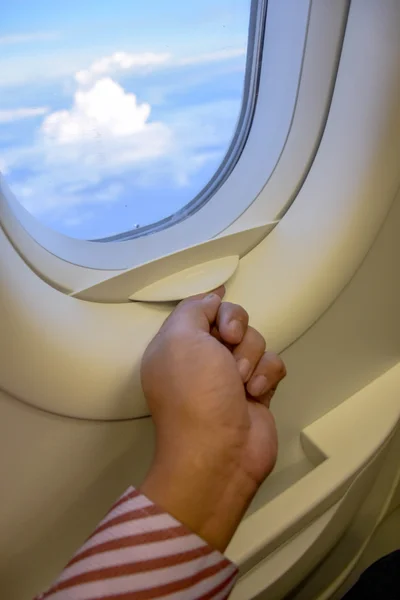 hand open plane windows with sky outside