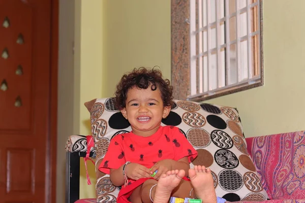 一个漂亮的印度小女孩坐在屋里的沙发上 微笑着看着摄像机 印第亚 — 图库照片