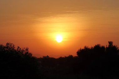 Manzara sabah görüntüsü Parlak güneşin tepeden ve siluetten gökyüzüne girdiği güneşin doğuşunun fotoğrafı.