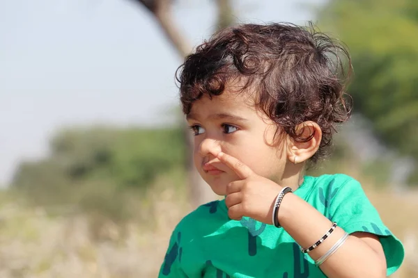 一个来自印第安农民家庭的小男孩站在田野里 看着远处的物体 用手指做着手势 这是他的近照 — 图库照片