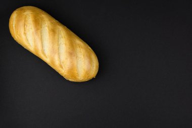 Siyah arka planda taze buğday somunu.