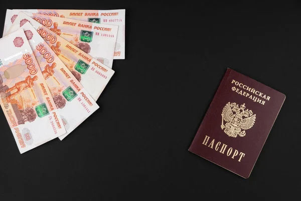 Russian passport and Russian currency close-up lying on a black background