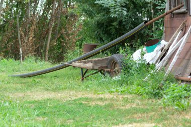 Arka bahçede ahşap ve metalden yapılmış eski bir bahçe arabası.