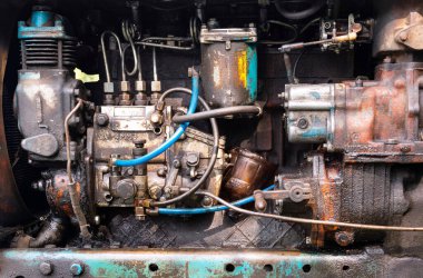 Eski bir traktörün motoru motor yağı ve yağ ile boyanmış.