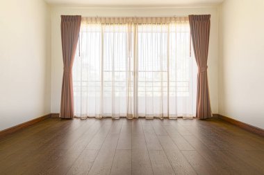 Boş odada ahşap zemin ve perdeler var, insan ve mobilya yok.