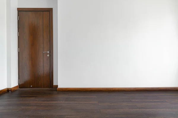 Boş odada ahşap zemin ve ahşap kapılar var.