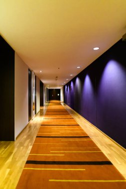 Renkli duvarları ve sıcak ışığı olan boş bir koridor..