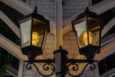 Tungsten ışığı beyaz tuğla arka planda lamba boyunca parlar