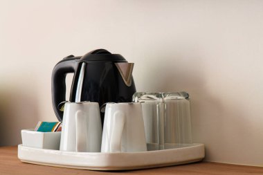 Otel odasında elektrikli çaydanlık ve kahve fincanı seti, seramik bardak seti.