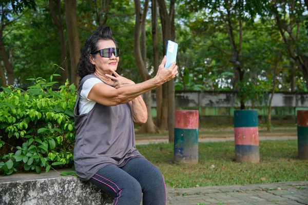 Büyükanne parkta yürüyüş ve egzersizin keyfini çıkar..