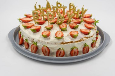 Beyaz arka planda izole edilmiş çilekli kek altın mumlarla süslenmiş doğum günü mektupları..