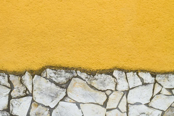 Žlutá stěna s kamenem — Stock fotografie